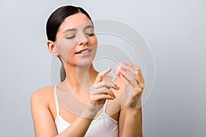Seasonal skin protection. smile woman applying lip protection balm against grey background