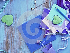 Seasonal summer composition of a pair of felt hearts, paper with a pencil, notebooks and decor