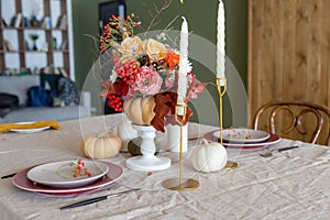 Seasonal table setting with plates, flowers and candles