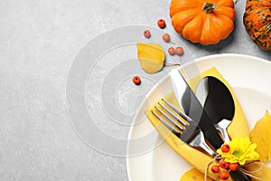 Seasonal table setting with pumpkins on light grey background, flat lay. Thanksgiving Day