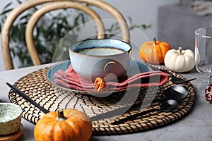 Seasonal table setting with pumpkins and other autumn decor in dining room