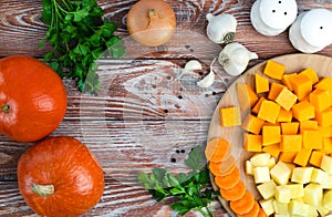 Seasonal vegetables for making pumpkin soup on wooden background. Top view. Copy space