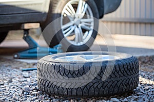 Seasonal winter tyre change. Snow tire lying on ground, is ready to install, spring