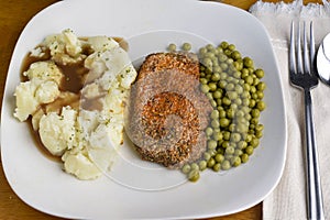 seasoned pork chop served with mash potatoes and peas