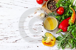 Seasoning background. Fresh and dry herbs, spices, olive oil and vegetables on a wooden table. Top view flat lay background.