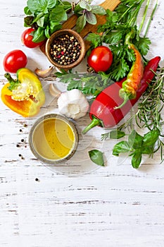 Seasoning background. Fresh and dry herbs, spices, olive oil and vegetables on a wooden table. Top view flat lay background. Copy