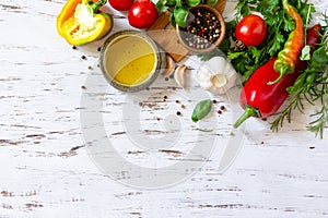 Seasoning background. Fresh and dry herbs, spices, olive oil and vegetables on a wooden table. Top view flat lay background.