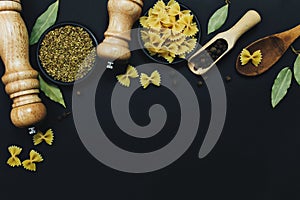 Seasonings  herbs and pasta on black background