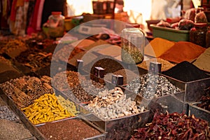 Seasonings and spices in assortment laid out in containers and sold at Goa market. Different flavorings on commerce.