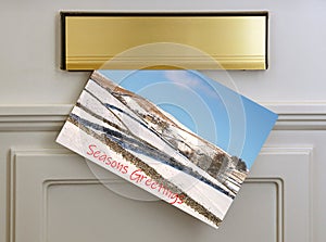 Seasons Greetings card in the letter box -wintry design