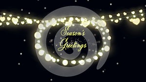 Seasons Greetings text and fairy lights against glowing spots on black background