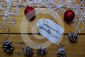 Seasons Greetings write on laber with wooden backgroud. Frame of Christmas Decoration