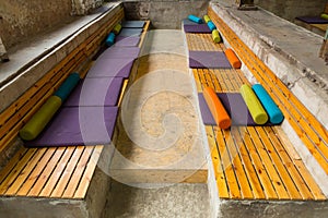 Seat made of wooden blocks and with multi-colored pillows of different shapes