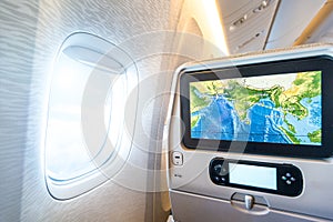 Seat monitor near window in passenger plane.