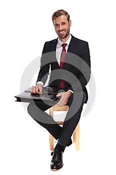 seated businessman waiting for job interview and opening suitcase