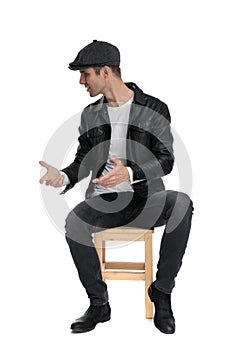 Seated casual man looking and talking to a side intrigued photo