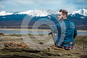 Seated  casual man looking to side and admiring the view