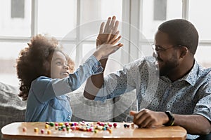 African daughter gives high five to father starting pastime activity photo