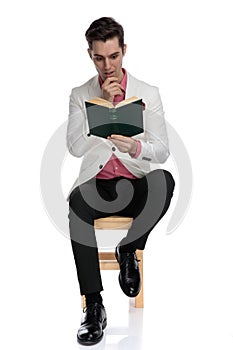 Seated elegant man is captivated by his interesting novel