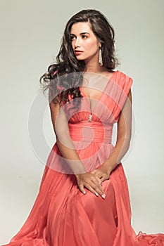 Seated elegant woman in red dress looking to side