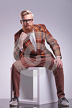 Seated fashion man with beard and glasses