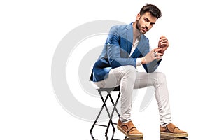 Seated fashion man with hands and palms together