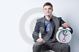 Seated Good Looking Businessman with Alarm Clock