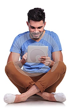Seated happy casual man working on his tablet