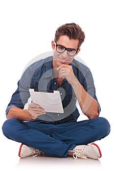 Seated man holds a tablet