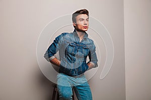 Seated man in jeans jacket dreaming away