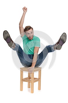 Seated modern man acting like a cowboy riding a chair