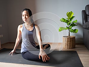 Seated spinal twist pose yoga asian woman home workout fitness body weight exercise pilates health training sport healthy