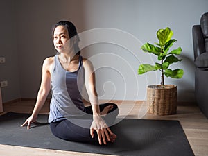 Seated spinal twist pose yoga asian woman home workout fitness body weight exercise pilates health training sport healthy