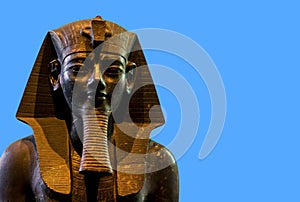 Seated statue of Amenhotep III on blue background