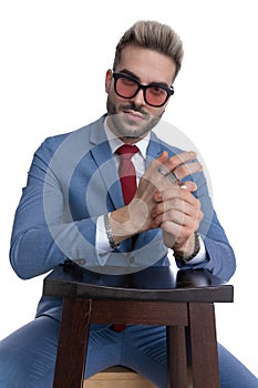 Seated young businessman rubbing his palms