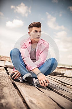 Seated young casual man looking away