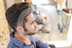 Seated young casual man with nice hairstyle