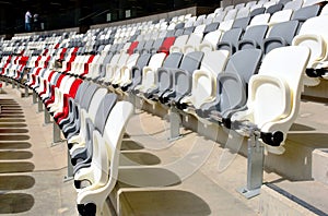 seating area detail of sport Stadium. curving rows of colorful plastic seats on steel frame.