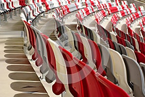 seating area detail of sport Stadium. curving rows of colorful plastic seats on steel frame.