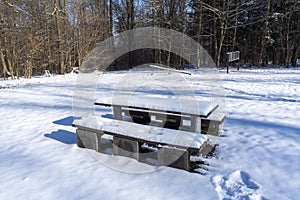 Seating group is snowed in in the winter forest