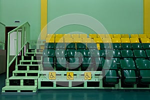 Seating seats sports hall. Green and yellow seats and seats for the disabled. Copy space. Territory without people