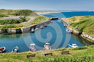 Seaton Sluice Harbour, a small inlet in Northumberland, Northern England with small boats. photo