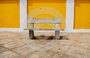 Seats against yello wall in Pondicherry, India