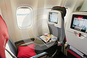 Seats on board of airplane. Cabin of economy class with screens