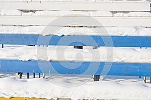 Seats in the stadium under the snow. Chairs for spectators at the stadium under the snow.