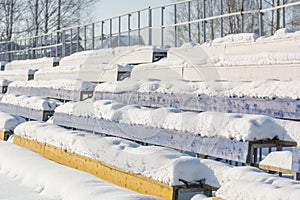 Seats in the stadium under the snow. Chairs for spectators at the stadium under the snow.