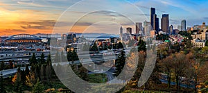 Seattle downtown skyline and skyscrapers beyond the I-5 I-90 freeway interchange at sunset in the fall with yellow foliage in the