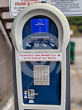 Selective focus on a public parking payment meter as it displays a `thank you` message