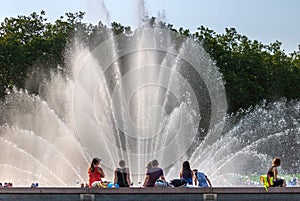 Seattle, Washington - 8/8/2018 : People outside enjoying a warm summer afternoon at the International Fountain in Seattle Center