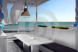Seaview Restaurant Interior. White Terrace With Wooden Furniture photo